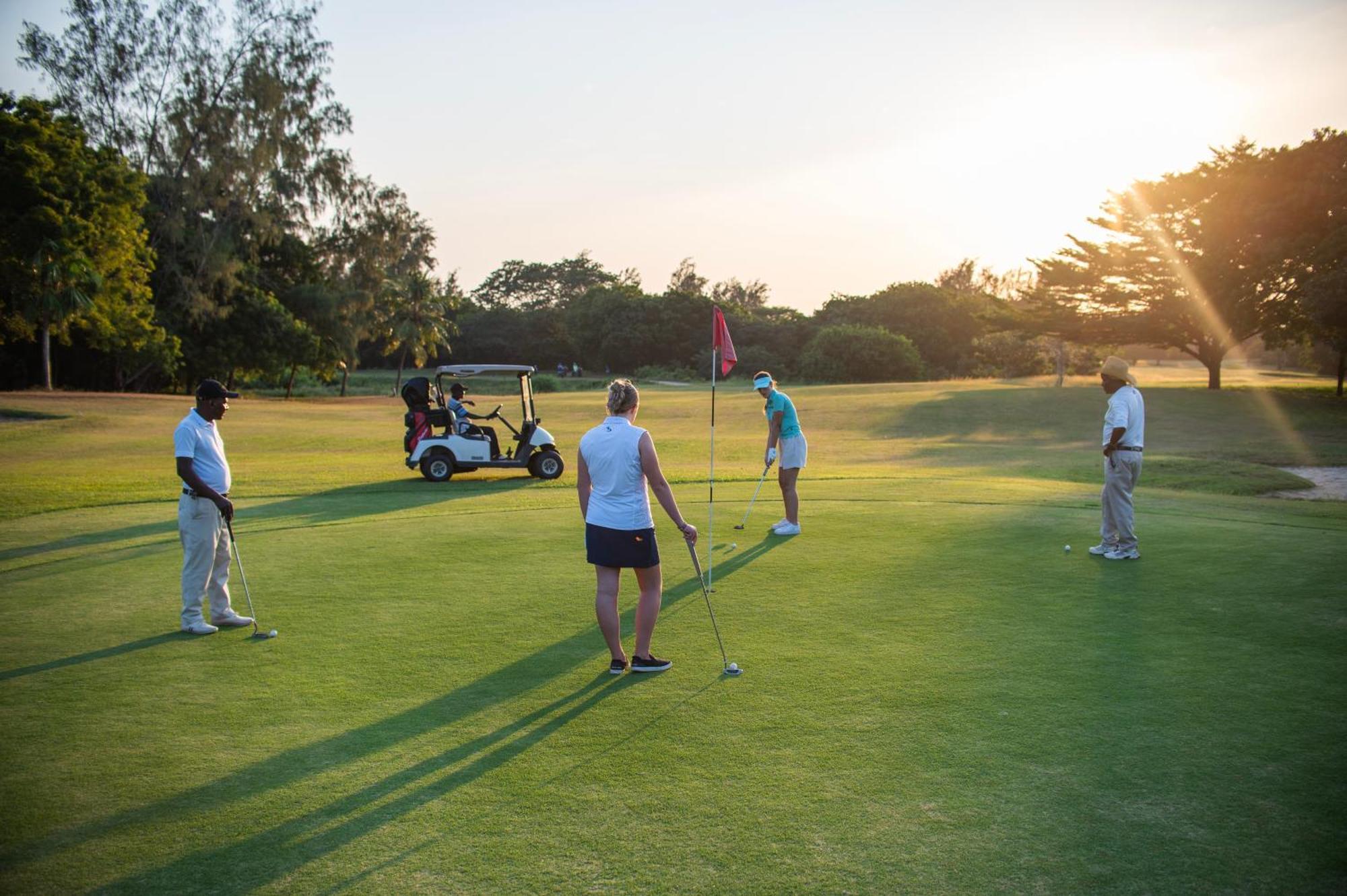 Diamonds Leisure Beach & Golf Resort Diani Beach Kültér fotó Golfers putting on the 18th green at the Royal Pines Resort